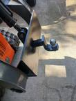 Black quick attach plate with 2-inch receiver and ball mount on an orange mini skid steer