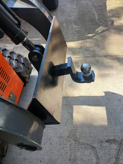 Black quick attach plate with 2-inch receiver and ball mount on an orange mini skid steer