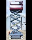 Skyjack scissor lift fully extended, maroon guardrail platform raised on a gray scissor stack