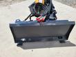 Wolverine stump grinder: skid steer quick-attach mount plate with bundled hydraulic hoses, grinder wheel behind
