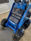 Blue AGT MX-MRW14 mini skid steer from behind, black stand-on operator platform between four knobby tires