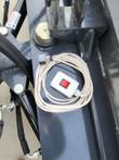 The blade's remote power switch: white on/off control box and coiled cable on the frame