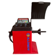 Red computer wheel balancer, side view with raised hood, weight-cup tray, control panel and threaded shaft