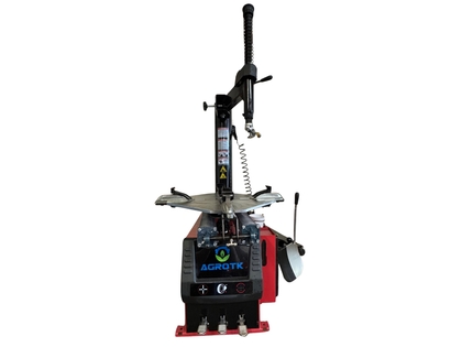 Red and black tire changer, front view with tower and mount arm, turntable, bead breaker pedal and foot pedals