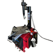 Red and black tire changer, angled view of turntable with four clamps, tower, air hose and foot pedals
