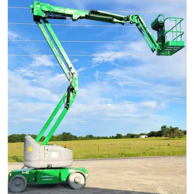 Green articulating boom lift with gray turret, boom raised and extended sideways, empty work platform at the end