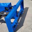 Blue skid steer quick-attach plate pinned to the auger swivel head, hydraulic hoses and black auger flighting behind