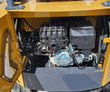 MX12RX mini excavator engine bay with the cowl open: OHV gasoline engine, caged muffler, carburetor and fuel tank