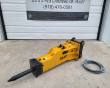 SB40 hydraulic breaker, yellow body with moil chisel fitted, black top mount and coiled hose pair