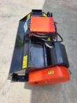 Flail mower from above: black deck, orange rear roller, hydraulic motor and coiled hose bundle