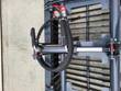 Hydraulic clamp cylinder barrel with coiled braided hose and red-capped quick couplers