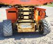 JLG rough terrain scissor lift from the rear: stacked scissor arms, engine cover and four-wheel-drive lug tires