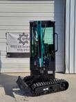 FF13 mini excavator head-on: boom cylinder folded in front of the cab, work lights, dozer blade and rubber tracks