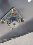 JCT concrete mixer bearing housing bolted to the drum, showing shaft cap and mounting bolts