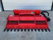 Red bi-directional power rake, black leveling teeth across the front edge and hydraulic hoses coiled at the side