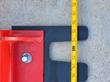Tape measure across the black toothed leveling bar of the red rake, marks around the 5-foot point