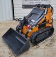 Landhero LDH-T460 mini skid steer, orange body and black hood, gray bucket lowered on rubber tracks