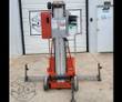 Orange push-around vertical mast lift with aluminum telescoping mast, outriggers extended and swivel casters