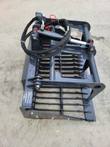 Landhonor rock grapple, spaced steel tines under a hydraulic top clamp arm, hoses coiled over the frame