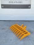 Yellow 38-inch excavator root rake, eight curved tines and twin pin-boss mounting ears