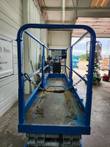 Scissor lift platform interior with entry chain, shop bay in background