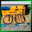 SDCH680 hydraulic hammer with black mount bracket, blue tool box and two coiled hydraulic hoses