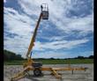 Yellow Haulotte 3632T towable boom lift with the boom raised near vertical on deployed outriggers