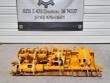 Yellow attachment package on a pallet below the shop address banner: auger bit, cylinder and buckets