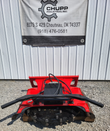 Red disc mulcher on a pallet, hydraulic drive motor and hoses on top, toothed cutting disc below