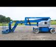 Blue Genie articulating boom lift, boom folded down over the chassis, work platform lowered, solid rubber tires