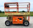 JLG 260MRT rough terrain scissor lift with the deck extension slid out, orange guardrails and operator control box
