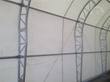 Dual truss galvanized steel arches and purlins inside the white PVC fabric building cover