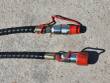 Two braided hydraulic hoses with red quick-connect couplers and dust caps