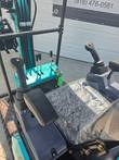KT13R mini excavator dual joystick controls and travel levers, seat still wrapped in plastic