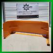 Orange snow plow blade front view, white poly cutting edge bolted across the base and angled end plates