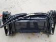 Black 4-in-1 mini skid steer bucket from the back: quick-attach mount plate, braided hoses and couplers