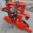 Orange TopCat tree shear from the side: skid steer mount plate, hydraulic cylinder and clamp arm, safety decals