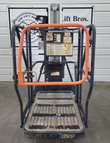 JLG 12SP platform from the front: orange guardrail gate, control panel placards and the 12SP-badged deck
