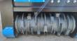 Mulcher's gray rotor drum with bolt-on cutter teeth and depth rings inside the blue and black housing