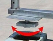 Container shelter twist-lock foot lowering into a shipping container corner casting, arrow showing the locking turn