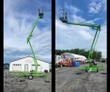 Green towable boom lift with the articulating boom raised and the work platform elevated