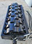 59-inch padfoot vibratory roller drum, black steel with staggered hex compaction pads and hydraulic hoses attached