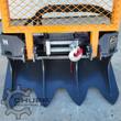 Arteer logging winch: cable drum and roller fairlead behind an orange mesh guard, chain locks and toothed anchor blade