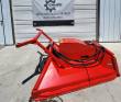 Red disc mulcher on its quick-attach frame, hydraulic hoses to the motor cover and toothed disc below
