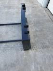 JCT double bale spear from the side: black quick-attach frame with the two round tine bars extending along the ground