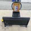 AGROTK 750 post driver from the mount side: universal skid steer quick-attach plate and the hammer's safety decals