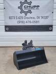 Black Future hydraulic tilt bucket, smooth-edge shell with tilt head and coiled hoses at the mount