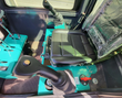 MH13RX cab interior: pilot joysticks with thumb buttons, padded seat, switch panel and red battery disconnect