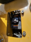 Fuel tank and filler cap of the MX12RX mini excavator, reached through a cutout in the cowl, with warning decal
