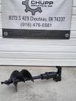 Black hydraulic auger with 16-inch bit below the Chupp Industrial shop banner